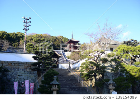 A view of the three-story pagoda from the stone steps in front of the grounds of Saikoku-ji Temple in Onomichi. 139154099