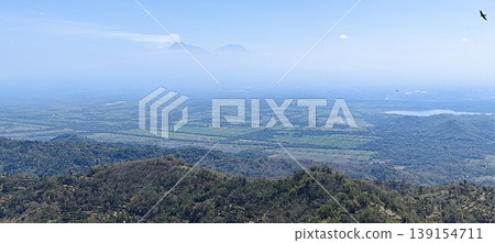 view of the land from the top of the hill with a cloudy blue sky view of the land from the top of the hill with a cloudy blue sky 139154711