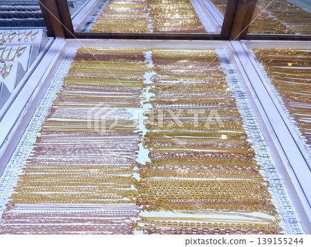 Photo of gold jewelry, necklaces, rings, bracelets in a glass display case Photo of gold jewelry, necklaces, rings, bracelets in a glass display case 139155244