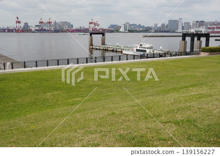 A view of Tokyo Bay: The lawn of Shiokaze Park in Odaiba and the Oi Container Terminal on the opposite shore. A view of Tokyo Bay: The lawn of Shiokaze Park in Odaiba and the Oi Container Terminal on the opposite shore. 139156227