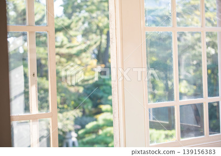 A stylish white-framed window bathed in sunlight; an image of a Western-style house, retro Western architecture, and interior design. A stylish white-framed window bathed in sunlight; an image of a Western-style house, retro Western architecture, and interior design. 139156383