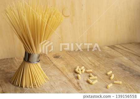 Bundle of dry spaghetti and fusilli pasta on wooden background 139156558
