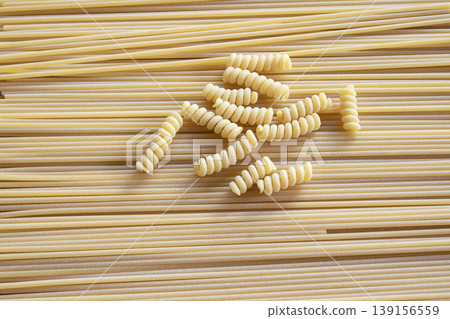 Fusilli and spaghetti dry pasta mix background texture 139156559