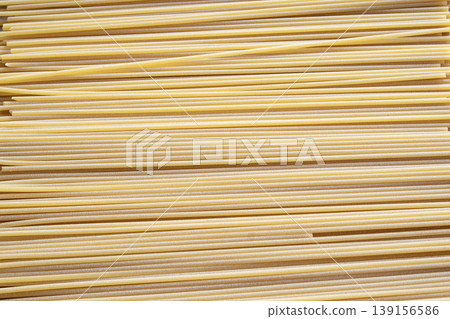 Dry spaghetti pasta strands arranged in horizontal rows background Dry spaghetti pasta strands arranged in horizontal rows background 139156586