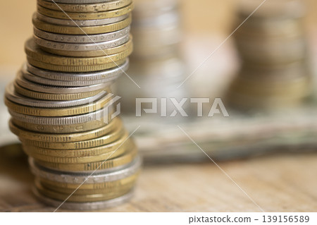 Stacked coins on wooden surface representing financial growth and savings Stacked coins on wooden surface representing financial growth and savings 139156589
