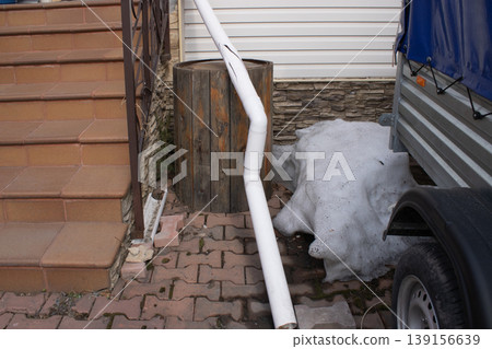 Cracked plastic rainwater drain pipe damaged by snow 139156639