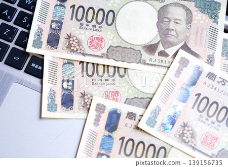 Image of an online business - An image of an online business utilizing the internet, using a computer and a 10,000 yen bill. Image of an online business - An image of an online business utilizing the internet, using a computer and a 10,000 yen bill. 139156735