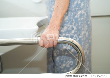 Asian elderly woman use safety handrail in bathroom. 139157332