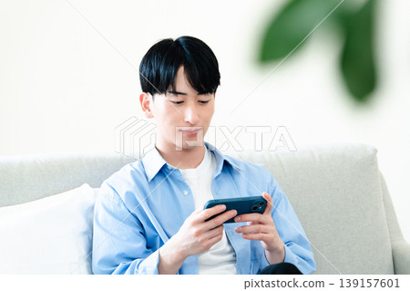 A man who uses a smartphone in the living room 139157601