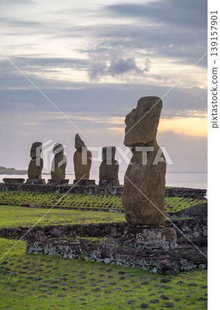 Peaceful moai stone statue standing on easter island chile under sunset sky Peaceful moai stone statue standing on easter island chile under sunset sky 139157901