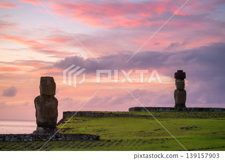 Peaceful moai statue stands on easter island chile under pink sunset sky Peaceful moai statue stands on easter island chile under pink sunset sky 139157903