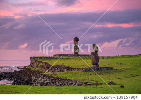 Peaceful moai statue standing on easter island chile coast at purple sunset Peaceful moai statue standing on easter island chile coast at purple sunset 139157904