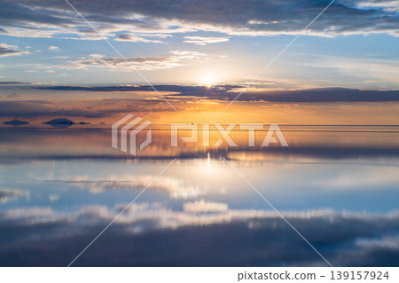 Serene sunset reflection on uyuni salt flat water in bolivia Serene sunset reflection on uyuni salt flat water in bolivia 139157924