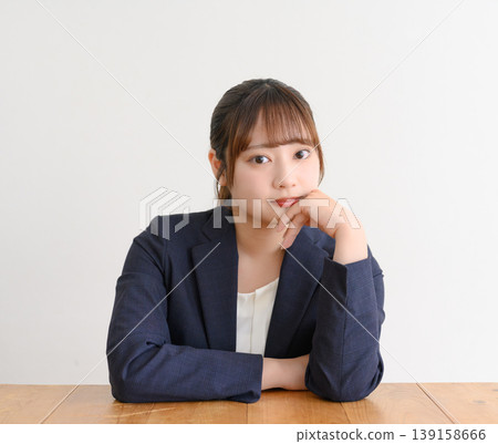 一位年輕女子坐在辦公桌前 139158666