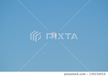 Moon and plane in the blue sky Moon and plane in the blue sky 139158918