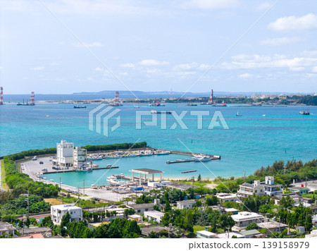 An aerial photograph of the fishing port and emerald green sea of Oura Bay in Okinawa Prefecture. An aerial photograph of the fishing port and emerald green sea of Oura Bay in Okinawa Prefecture. 139158979
