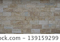 Natural facing stone in block masonry of a facade, fence or wall fragment, light brown decorative stone tiles in a building structure, finishing tiles made of natural solid stone for outdoor work. 139159299