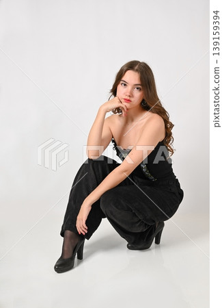 Studio portrait of a thoughtful teenage girl with dark hair 139159394