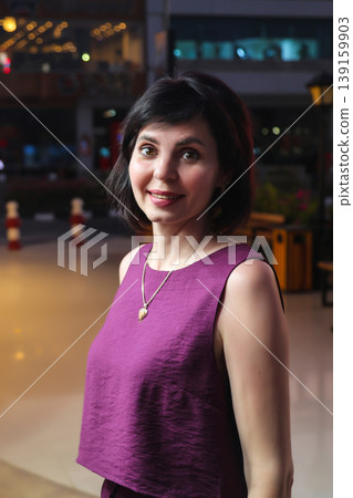 An adult woman near a store window late in the evening An adult woman near a store window late in the evening 139159903