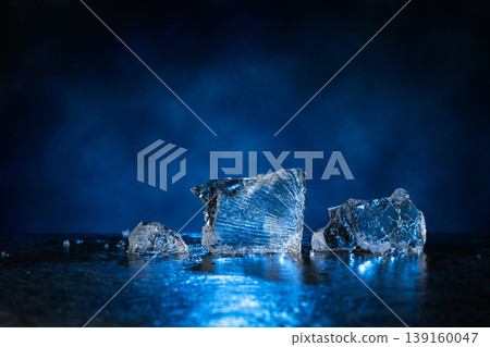 Broken ice with blue backlight on a dark background. Broken ice with blue backlight on a dark background. 139160047
