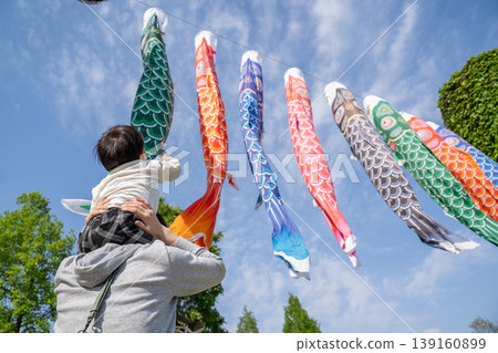 A child reaches out to a carp streamer. A child reaches out to a carp streamer. 139160899