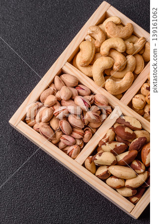 A box of cashews, hazelnuts, pistachios, and Brazil nuts as healthy food ingredients. A box of nuts 139161062