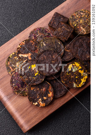 Organic Chinese green pu-erh tea with various herbs in round bricks. Chinese pu-erh tea Organic Chinese green pu-erh tea with various herbs in round bricks. Chinese pu-erh tea 139161092
