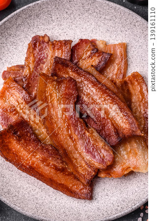 Fried fresh bacon slices with layers of meat or prosciutto prepared for breakfast. Fried bacon Fried fresh bacon slices with layers of meat or prosciutto prepared for breakfast. Fried bacon 139161110