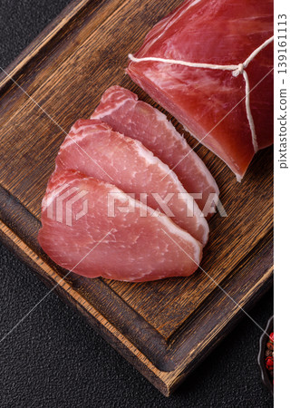 Smoked or dry cured meat slices, pork or ham with salt and spices. Smoked meat slices Smoked or dry cured meat slices, pork or ham with salt and spices. Smoked meat slices 139161113