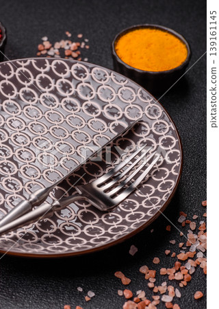 An empty ceramic round plate, kitchen utensils for a dinner table. An empty plate An empty ceramic round plate, kitchen utensils for a dinner table. An empty plate 139161145