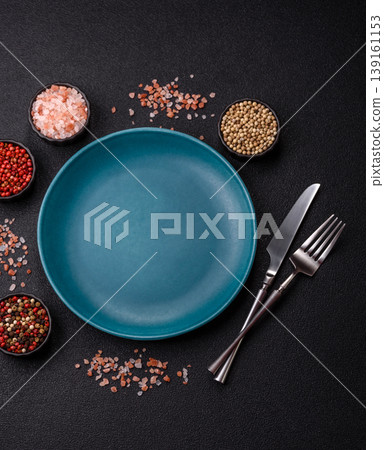 An empty ceramic round plate, kitchen utensils for a dinner table. An empty plate 139161153