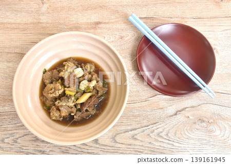boiled braised beef meat and tendon in herb brown soup on bowl with plate and chopsticks 139161945