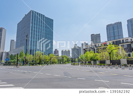 A modern Chinese city intersection and glass-fronted office buildings stand out against the blue sky and greenery. A modern Chinese city intersection and glass-fronted office buildings stand out against the blue sky and greenery. 139162192