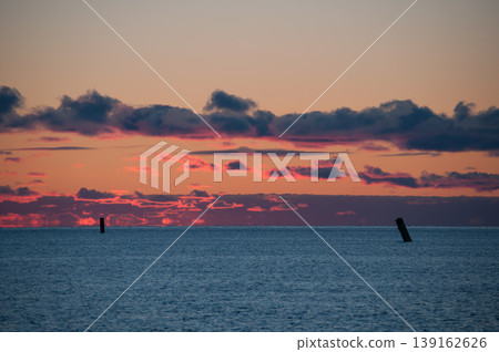 Navigational buoys in the Gulf of Bothnia near the Finnish coast with the red colors of setting sun in the horizon 139162626