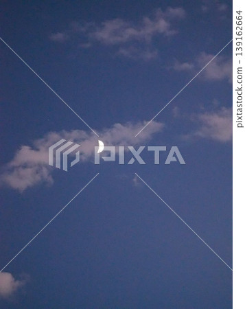 一輪彎月懸掛在暮色的天空。 一輪彎月懸掛在暮色的天空。 139162664