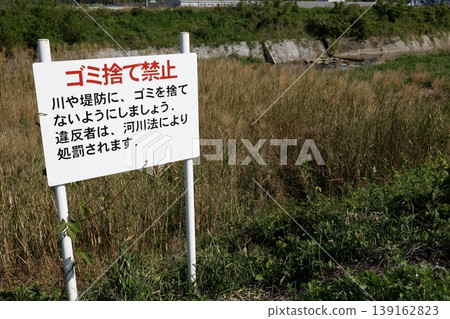 A sign prohibiting littering is posted on the river. The warning is in red letters. This is a violation of the River Act. A sign prohibiting littering is posted on the river. The warning is in red letters. This is a violation of the River Act. 139162823
