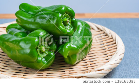 篩子上的甜椒-一種天然的綠色蔬菜食材,可供餐桌享用。 篩子上的甜椒-一種天然的綠色蔬菜食材,可供餐桌享用。 139163385