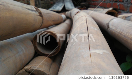 Bamboo Pipes Arranged in Construction Area with Red Brick Background Bamboo Pipes Arranged in Construction Area with Red Brick Background 139163756