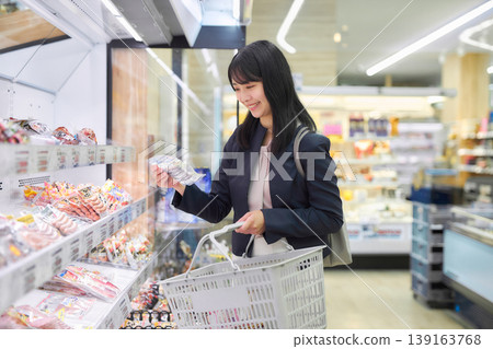 一位女商人正在超市挑選肉類。 139163768