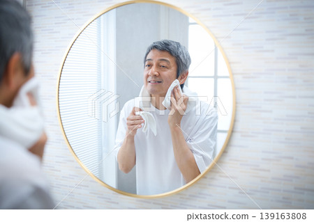 A man in his 60s smiling in the mirror - Men's beauty image A man in his 60s smiling in the mirror - Men's beauty image 139163808