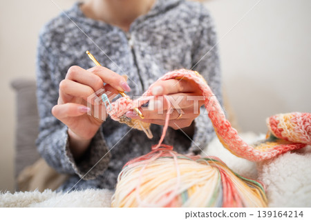 Close-ups of a woman's hands and yarn as she creates handmade items using crochet. 139164214