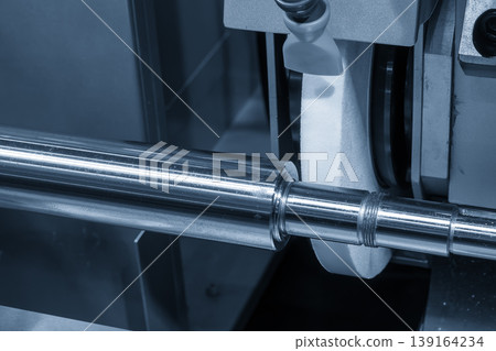 High-precision cylindrical grinding machine finishing a metal shaft for a smooth surface in a smart factory. High-precision cylindrical grinding machine finishing a metal shaft for a smooth surface in a smart factory. 139164234