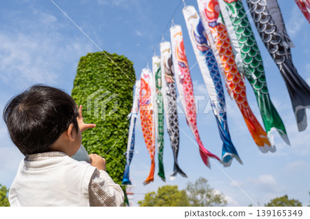 A boy reaches out his hand to a carp streamer. A boy reaches out his hand to a carp streamer. 139165349