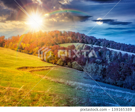 day meet night. nice view of an autumn scenery in carpathian mountains. sun and moon in harmony over trees on the edge of a hill in fall colors at twilight. wonderful forested mountain landscape day meet night. nice view of an autumn scenery in carpathian mountains. sun and moon in harmony over trees on the edge of a hill in fall colors at twilight. wonderful forested mountain landscape 139165389