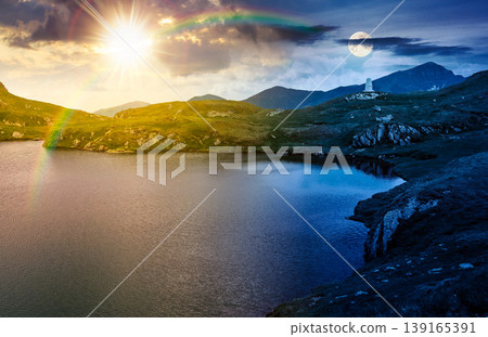 summer solstice scenery of alpine capra lake with steep slopes. day meet night. epic view of transylvania alps. sun and moon in harmony over southern carpathian mountains for astrology wallpaper summer solstice scenery of alpine capra lake with steep slopes. day meet night. epic view of transylvania alps. sun and moon in harmony over southern carpathian mountains for astrology wallpaper 139165391