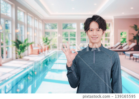 一個年輕男子在游泳池裡微笑 一個年輕男子在游泳池裡微笑 139165595