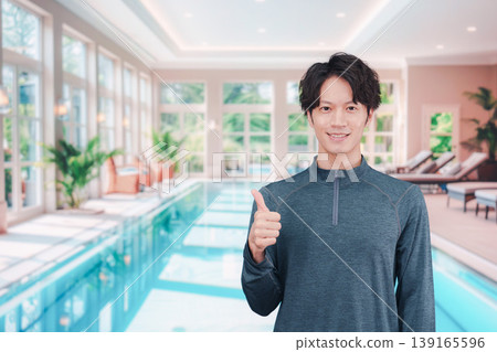 一個年輕男子在游泳池裡微笑 一個年輕男子在游泳池裡微笑 139165596