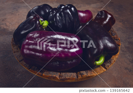 assortment of bell peppers, purple and black peppers, in a wooden bowl, top view, no people, assortment of bell peppers, purple and black peppers, in a wooden bowl, top view, no people, 139165642