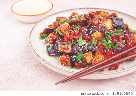 fried eggplant, Chinese style, in sweet and sour sauce, with pepper and sesame seeds. on a white plate, fried eggplant, Chinese style, in sweet and sour sauce, with pepper and sesame seeds. on a white plate, 139165646