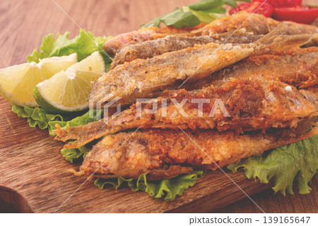 Fried crispy red mullet fish, on a wooden chopping board, with lime, no people, Fried crispy red mullet fish, on a wooden chopping board, with lime, no people, 139165647